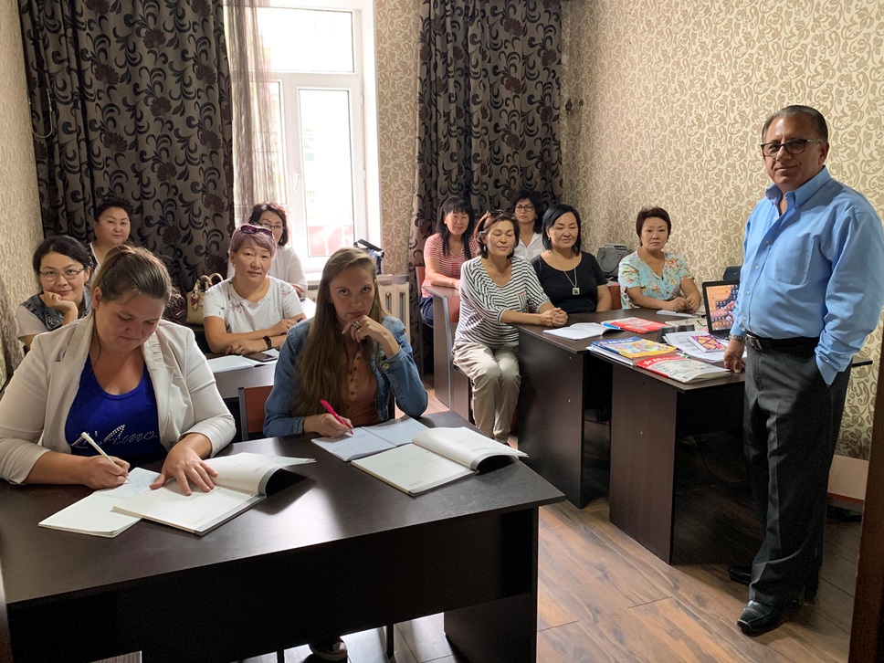Nick with a group of women studying English in a classroom